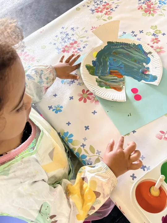 A child exploring colour through a painting activity