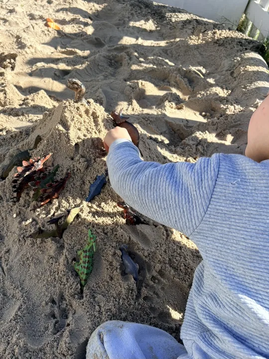 A child exploring outdoor sand play