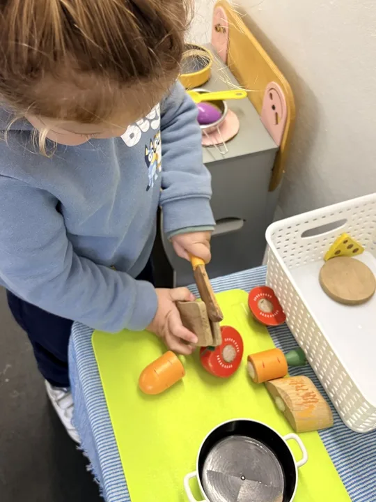 A child using a toy hammer in a practical-life activity