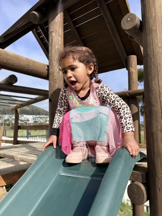 A child enjoying the outdoor slide