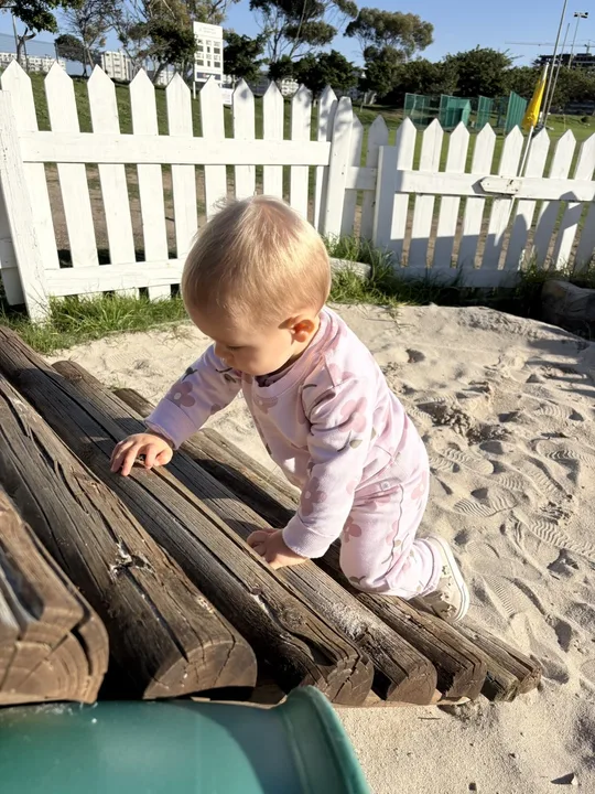 A toddler climbing confidently outdoors