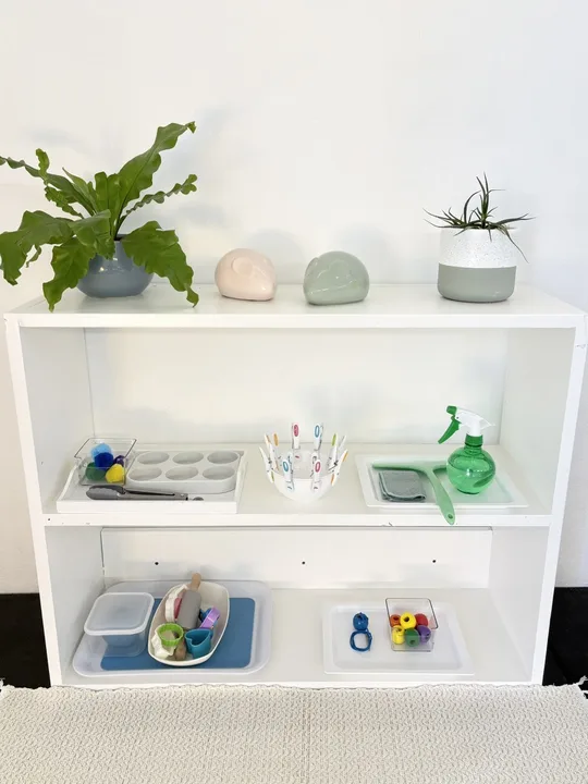 A low Montessori shelf prepared for the morning