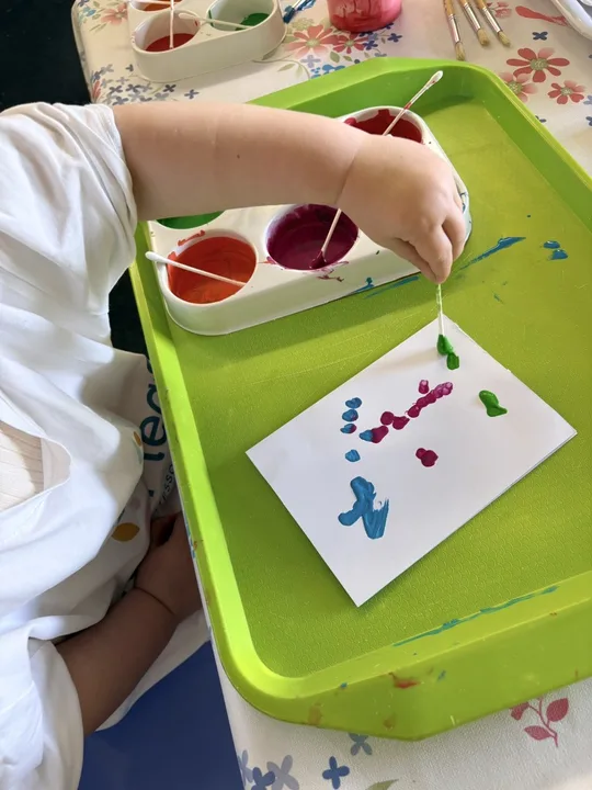 A child creating a small painted picture