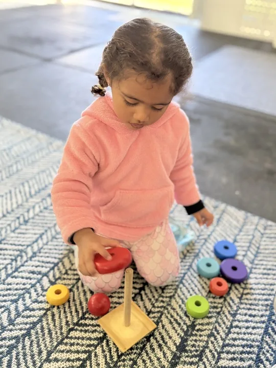A child working with a threading and sorting activity