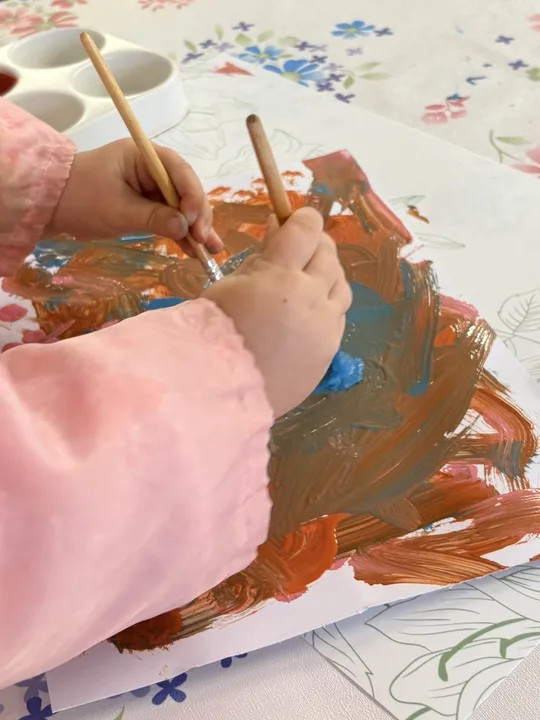 A child painting freely at the activity table