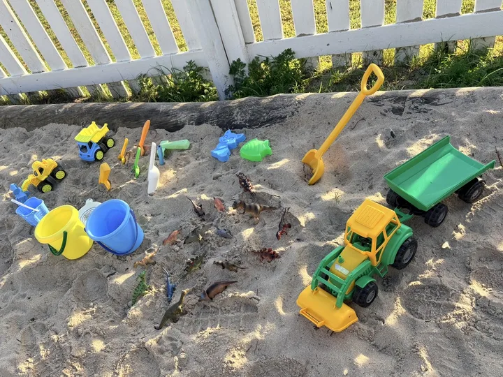 A prepared outdoor sand area with toys