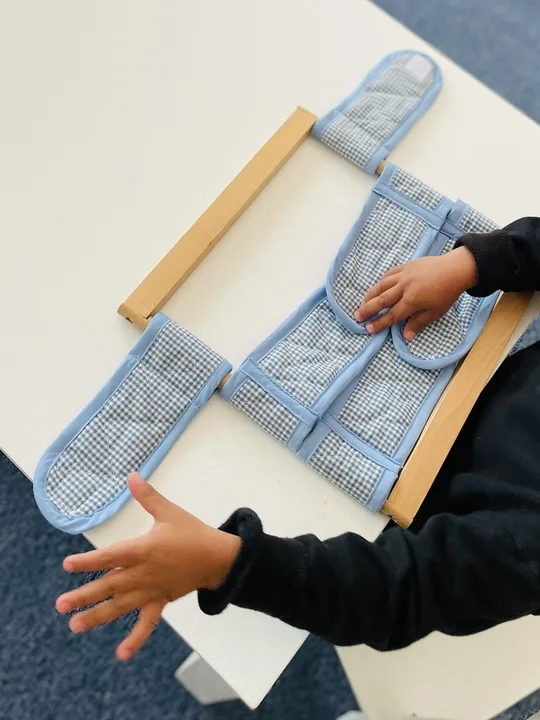 A child working with a dressing frame