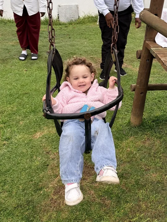 A toddler enjoying the outdoor swing
